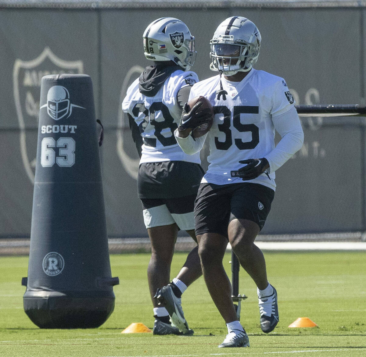 Raiders running back Zamir White (35) runs a drill past Josh Jacobs (28) during practice at the ...