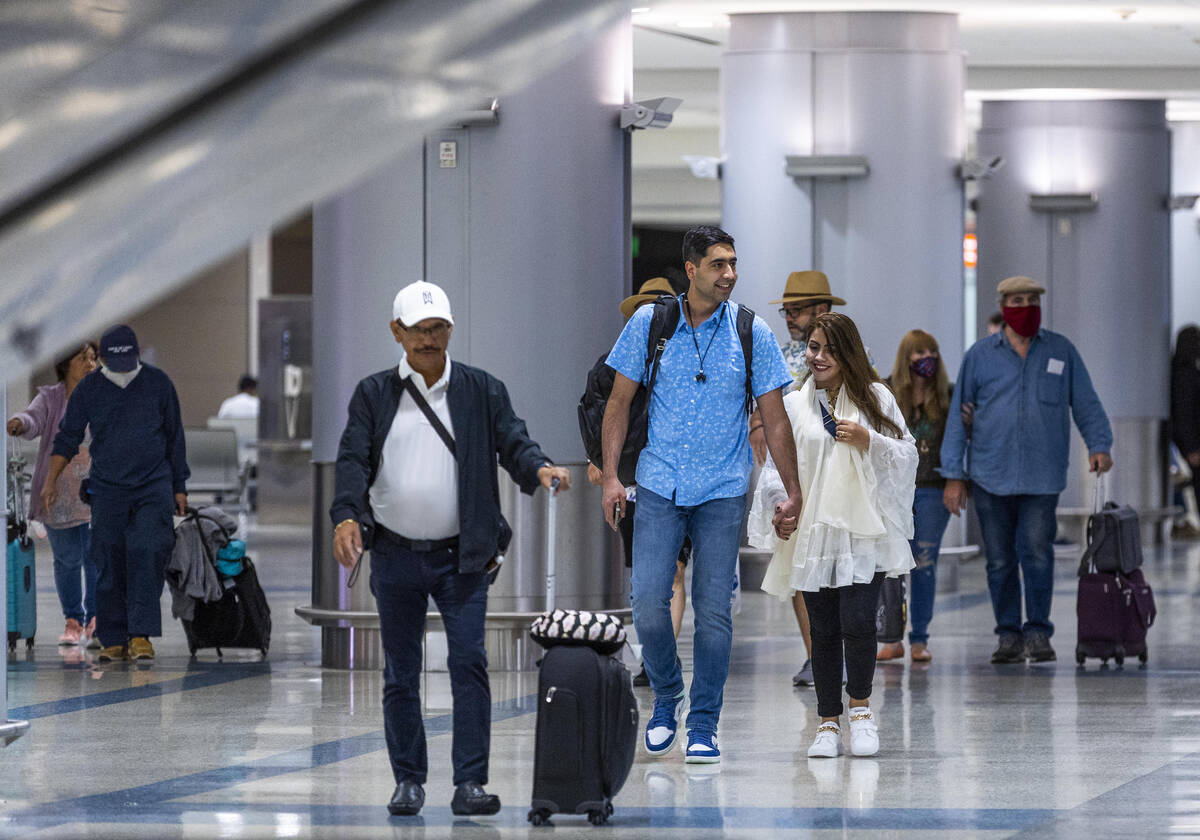 Mohammad "Benny" Shirzad and his wife, Shabana, walk through baggage claim after arriving just ...