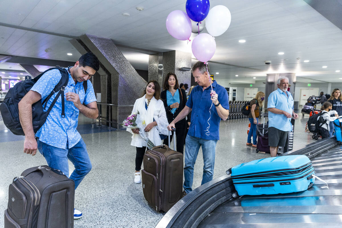 (From left) Mohammad "Benny" Shirzad grabs bags for his wife, Shabana, as Ellen and Scott Hoffm ...