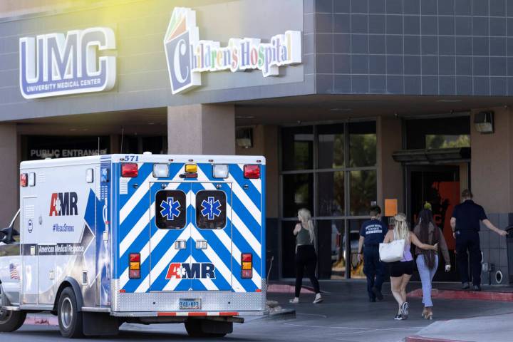 People enter the University Medical Center trauma department after two people were killed and s ...