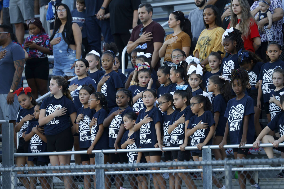 Shadow Ridge High School fans are seen during the national anthem before a football game agains ...