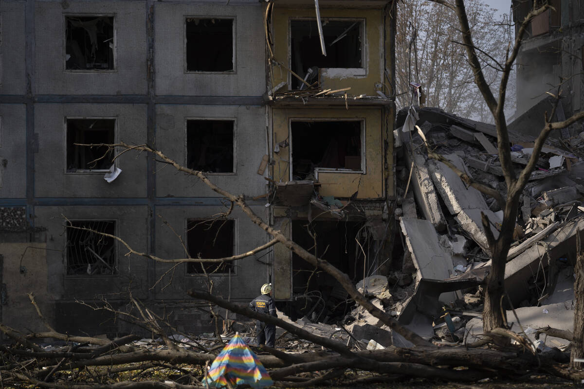 A firefighter looks on as he stands at the scene of a building that was heavily damaged after a ...