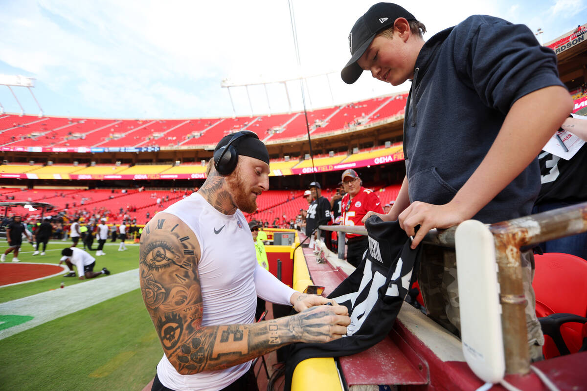 Raiders defensive end Maxx Crosby (98) signs an autograph for Adon McDowell, 15, of Yreka, Cali ...