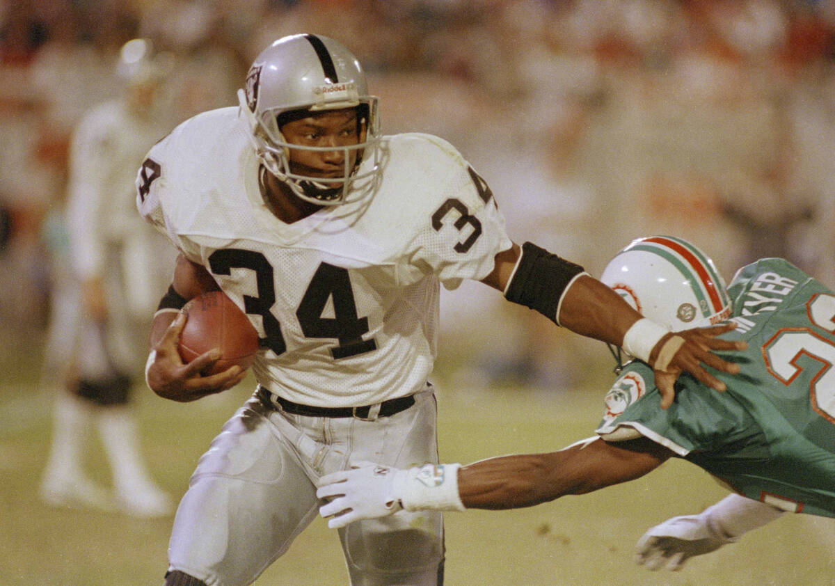 Los Angeles Raiders running back Bo Jackson (34) pushes away Miami Dolphins corner back Tim McK ...