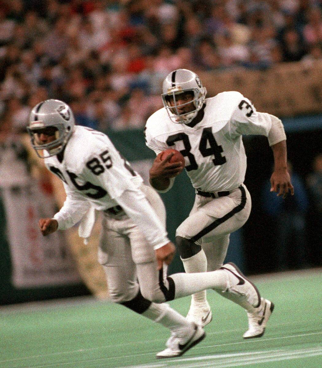 Los Angeles Raiders Bo Jackson (34) follows Dokie Williams (85) for a four-yard gain in the fir ...