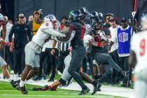 UNLV Rebels quarterback Doug Brumfield (2) is hit late on the sidelines by New Mexico Lobos lin ...