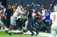 UNLV Rebels quarterback Doug Brumfield (2) is hit late on the sidelines by New Mexico Lobos lin ...