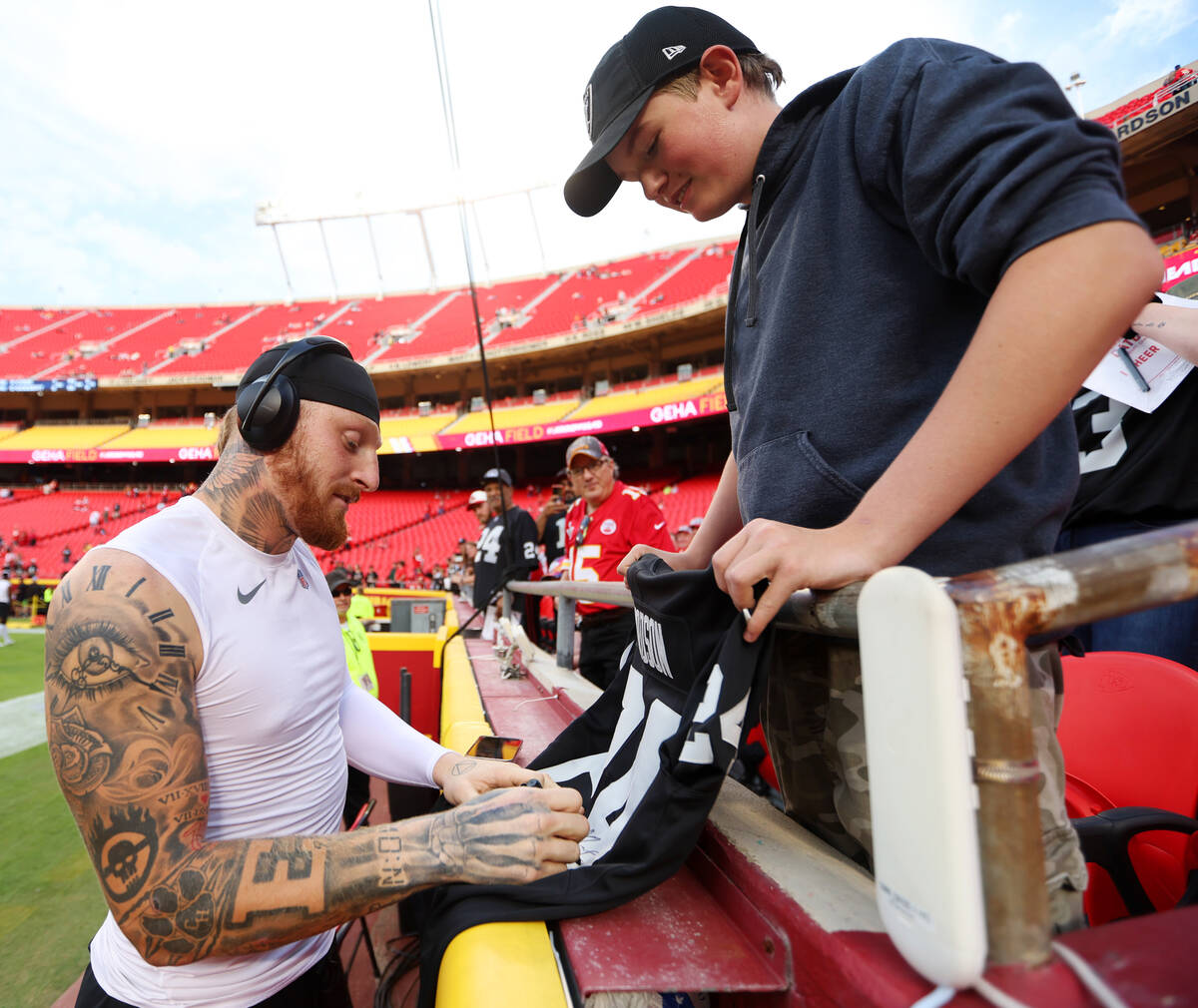 Raiders defensive end Maxx Crosby (98) signs an autograph for Adon McDowell, 15, of Yreka, Cali ...