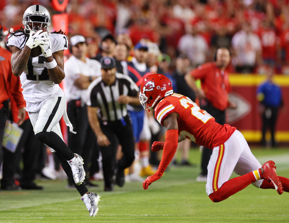 Raiders wide receiver Davante Adams (17) makes a catch under pressure from Kansas City Chiefs s ...
