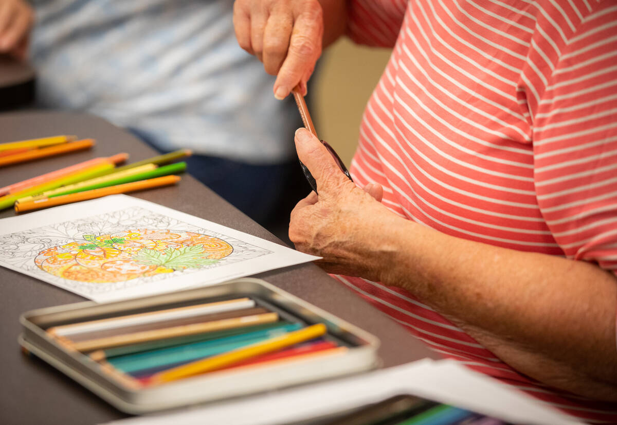 Malinda Henry, 70, sharpens her color pencil during an Adult Coloring and Journaling session at ...