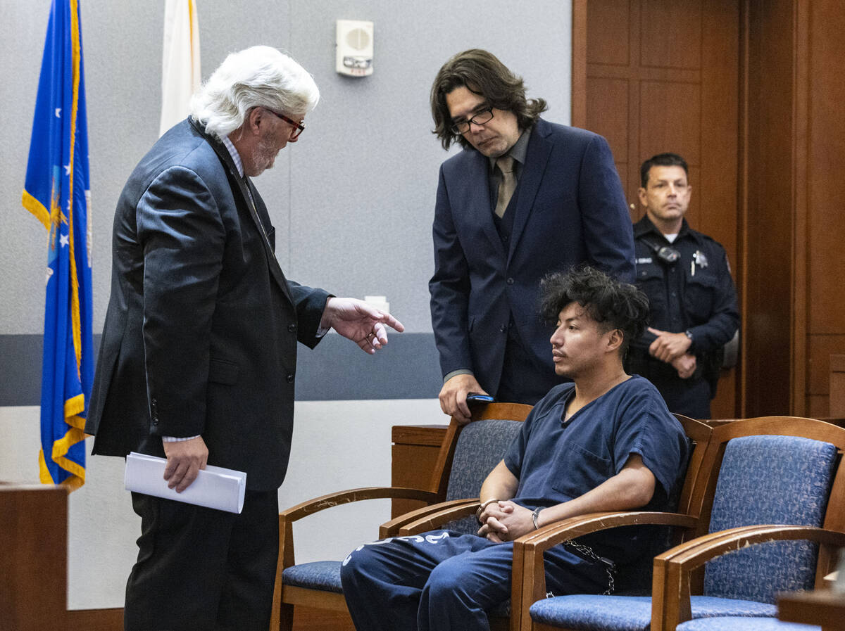 Yoni Barrios listens to Scott Coffee, left, and Jeff Maningo, public defenders, during a status ...