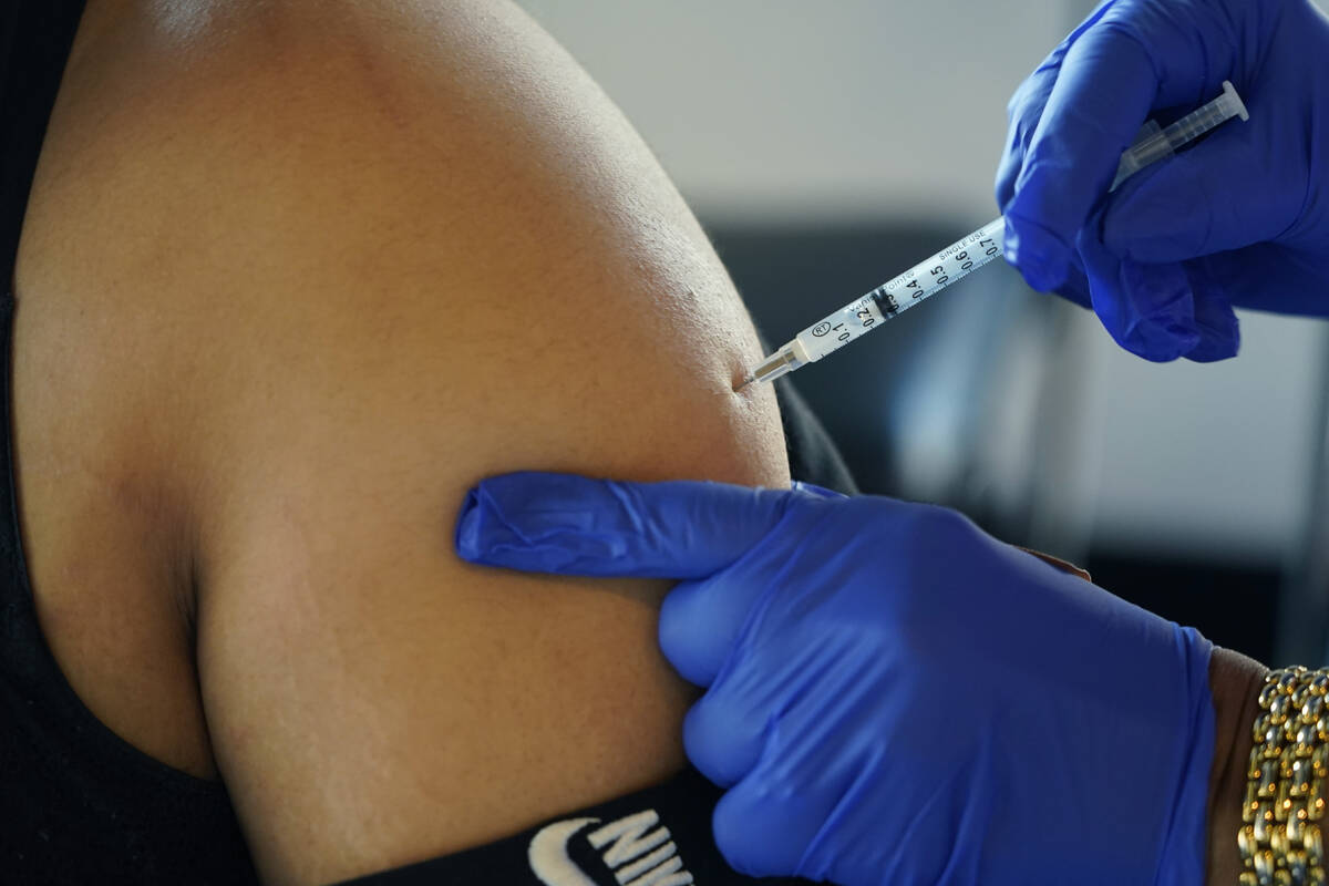 A Jackson, Miss., resident receives a Pfizer booster shot from a nurse at a vaccination site Fe ...