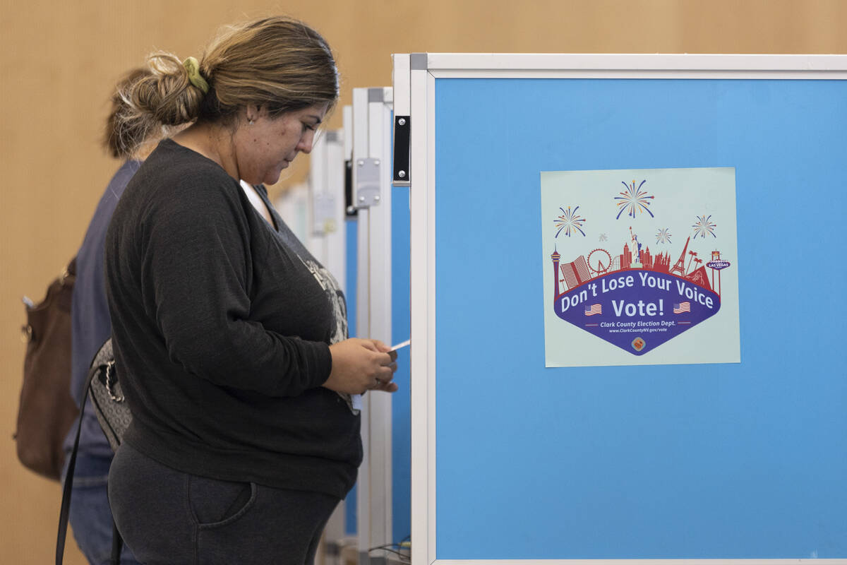 Karina Castro of Las Vegas casts her vote at the polling place inside of the East Las Vegas Lib ...