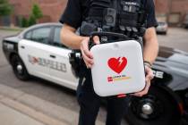 A police officer holds an automated external defibrillator (AED). A $6.9 million grant from the ...