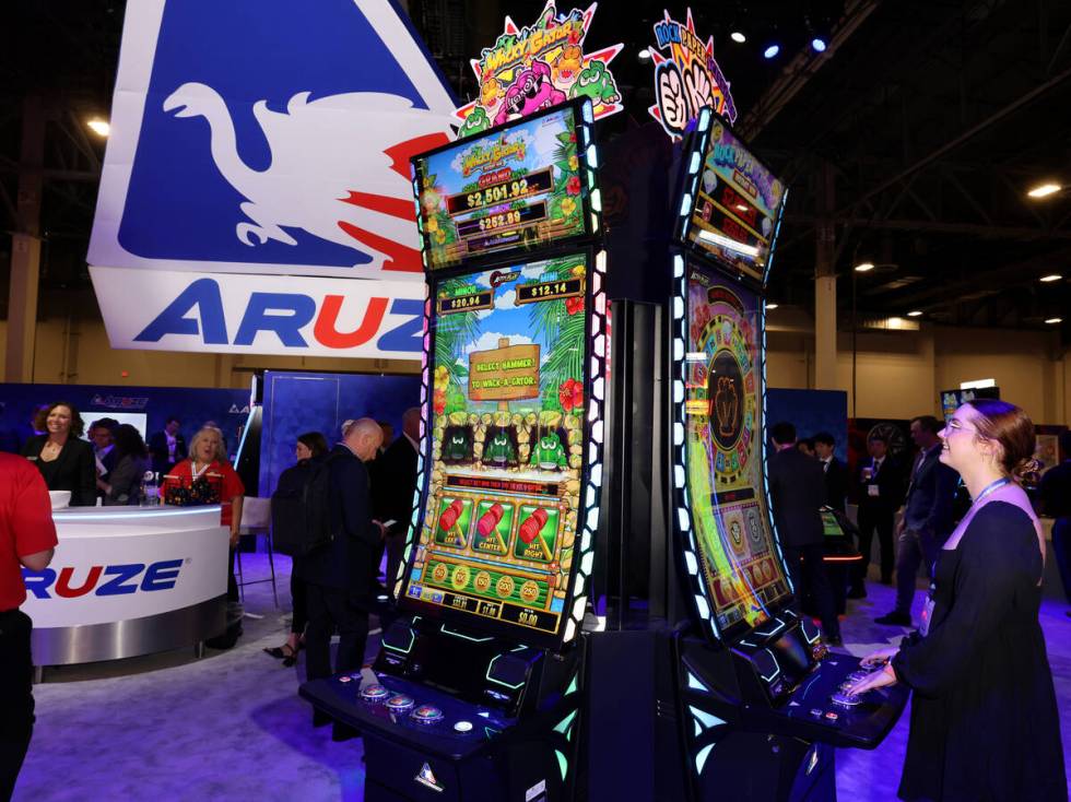 Cailey Henderson memainkan permainan slot Rock Paper Scissors di stan Aruze Gaming America di…
