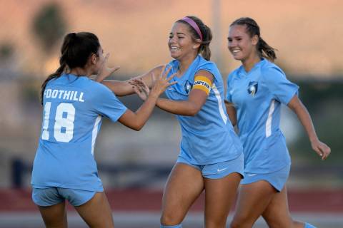 Foothill’s Brooklynn Phelps (18) congratulates her teammate Isabelle Simoneau, center, after ...