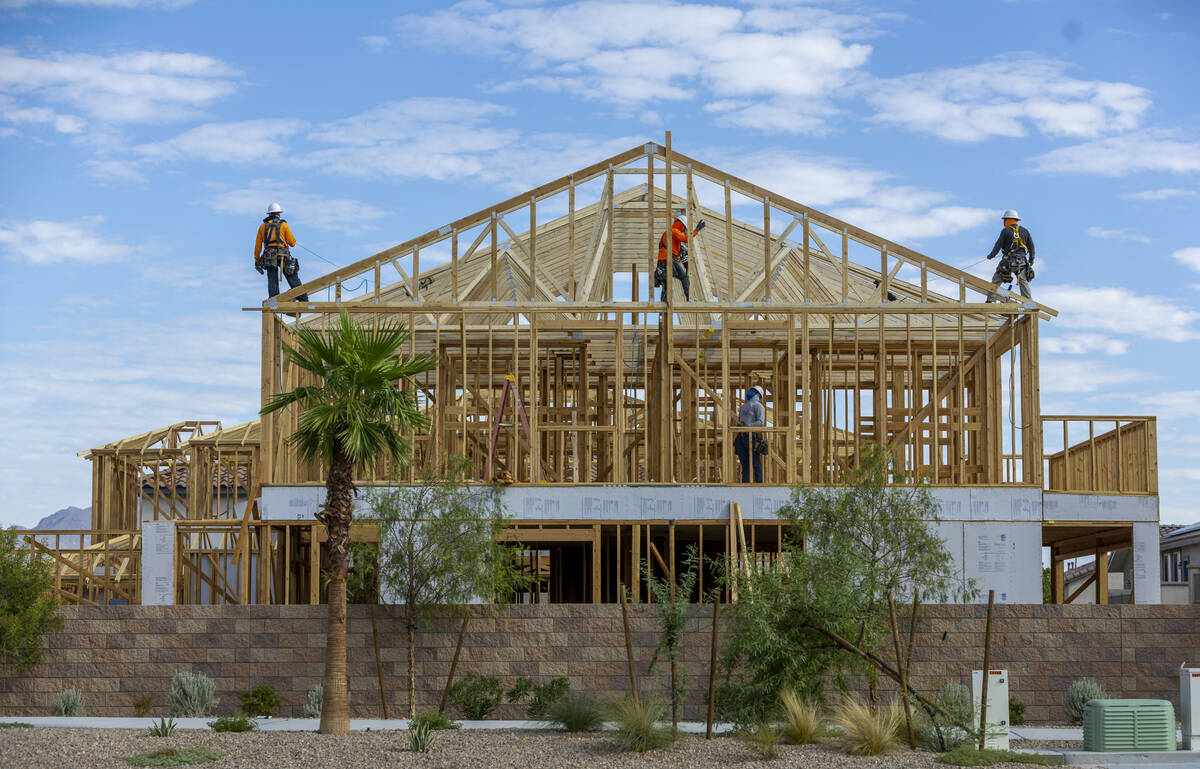 A construction crew works on the frame of a new house within The McAuley far east on Galleria D ...