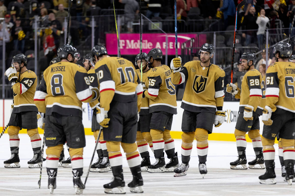 The Golden Knights throw their sticks up after winning their first regular season home NHL hock ...