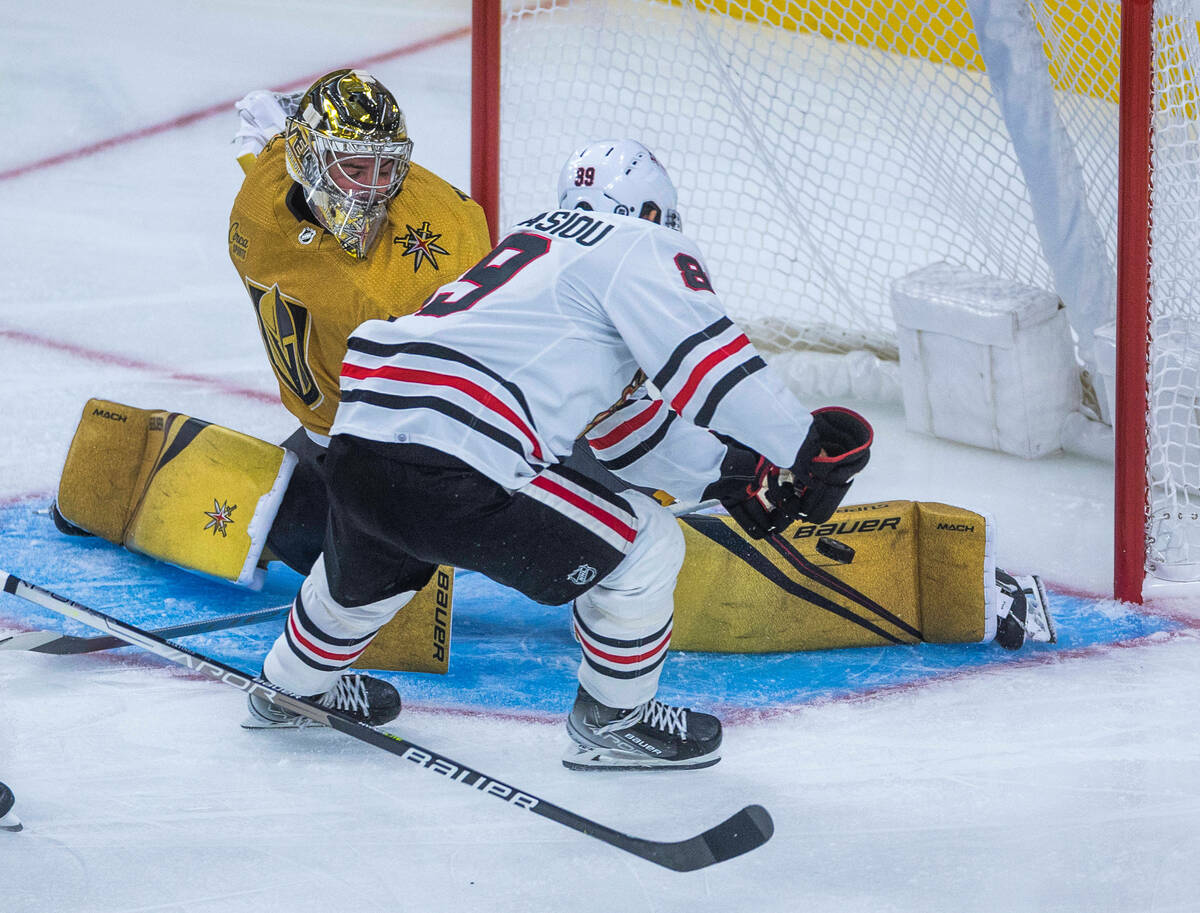 Golden Knights goaltender Logan Thompson (36) deflects a shot off his pad by Chicago Blackhawks ...