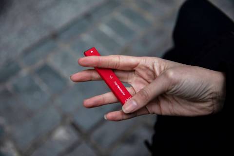 FILE - In this Jan. 31, 2020 photo a woman holds a flavored disposable vape device in New York. ...