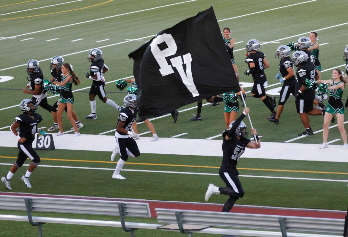 Palo Verde’s Dustin Kane, center, runs out to the field with holding a flag before a foo ...