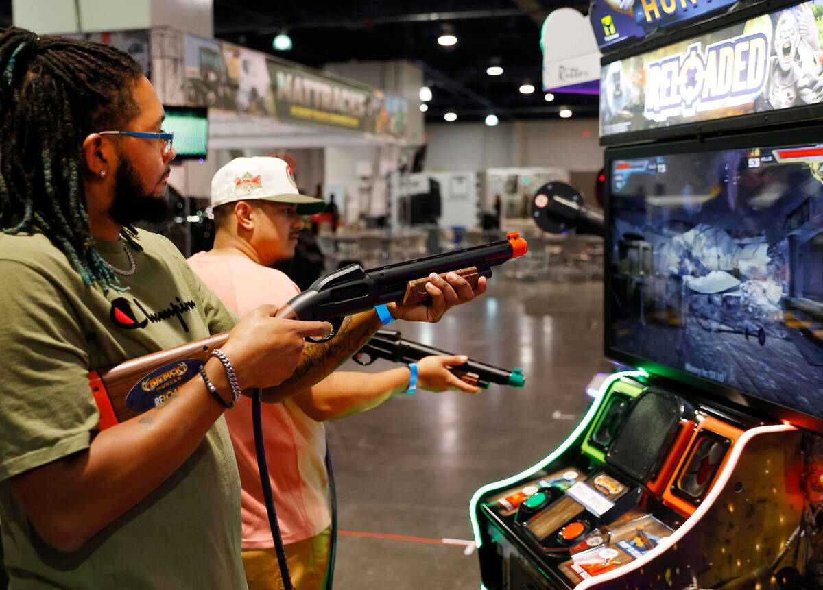 Dionte Love, left, and Claudio Solis play a video game at Big Boys Toys Innovation and Luxury L ...