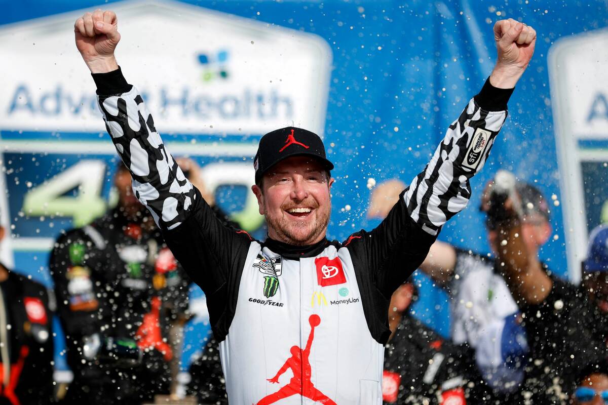 Kurt Busch celebrates in victory lane after winning a NASCAR Cup Series auto race at Kansas Spe ...