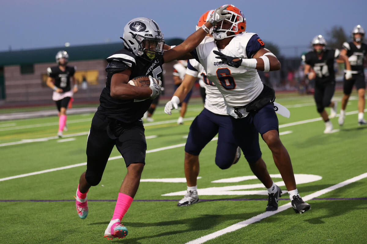 Palo Verde's Bryant Johnson (25) runs the ball under pressure from Bishop Gorman's Jeremiah Hug ...