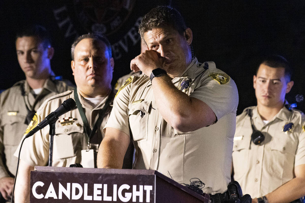 Las Vegas police officer Greg Hilton weeps as he speaks during a candlelight vigil for fallen o ...
