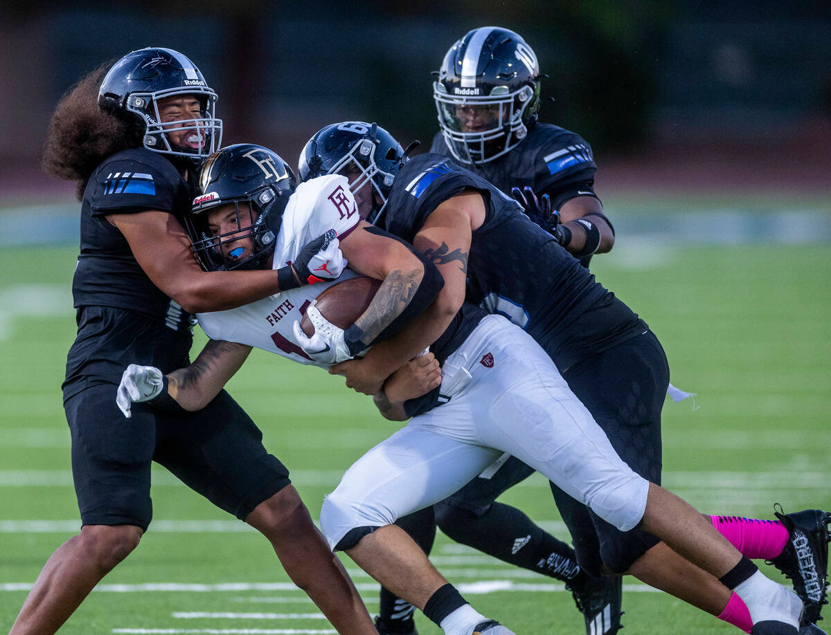 Desert Pines OLB Isaiah Teo (14) tackles Faith Lutheran's RB Cale Breslin (14) with help from D ...
