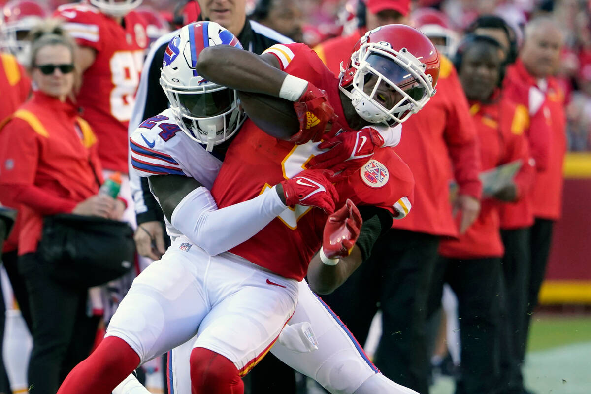 Kansas City Chiefs wide receiver JuJu Smith-Schuster, front, is tackled by Buffalo Bills corner ...
