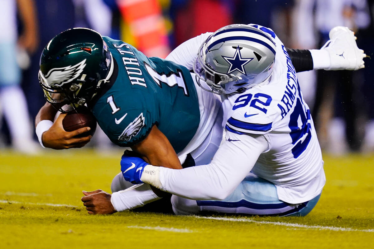 Dallas Cowboys' Dorance Armstrong tackles Philadelphia Eagles' Jalen Hurts during the first hal ...