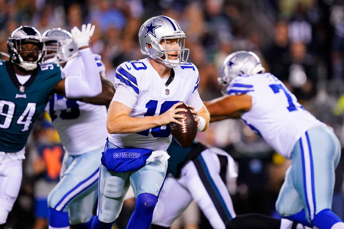 Dallas Cowboys' Cooper Rush, center, looks to pass during the first half of an NFL football gam ...