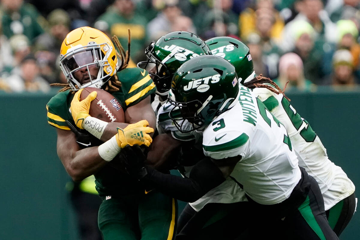 Green Bay Packers running back Aaron Jones, left, is stopped during the second half of an NFL f ...