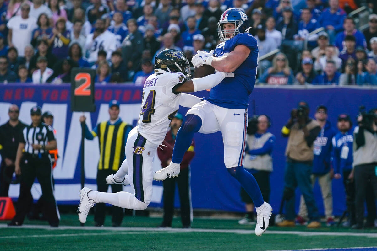 New York Giants' Daniel Bellinger, right, catches a pass for a touchdown in front of Baltimore ...
