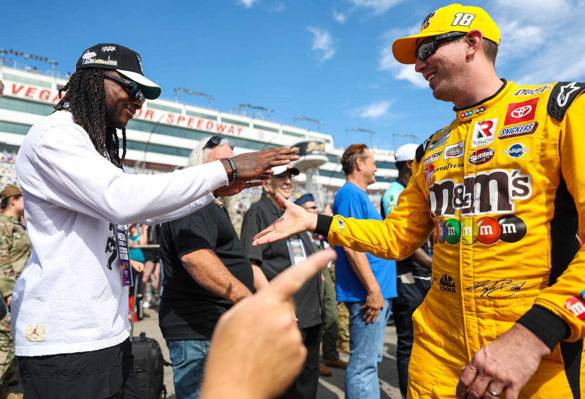 Honorary pace car driver Davante Adams of the Raiders, left, greets driver Kyle Busch before th ...