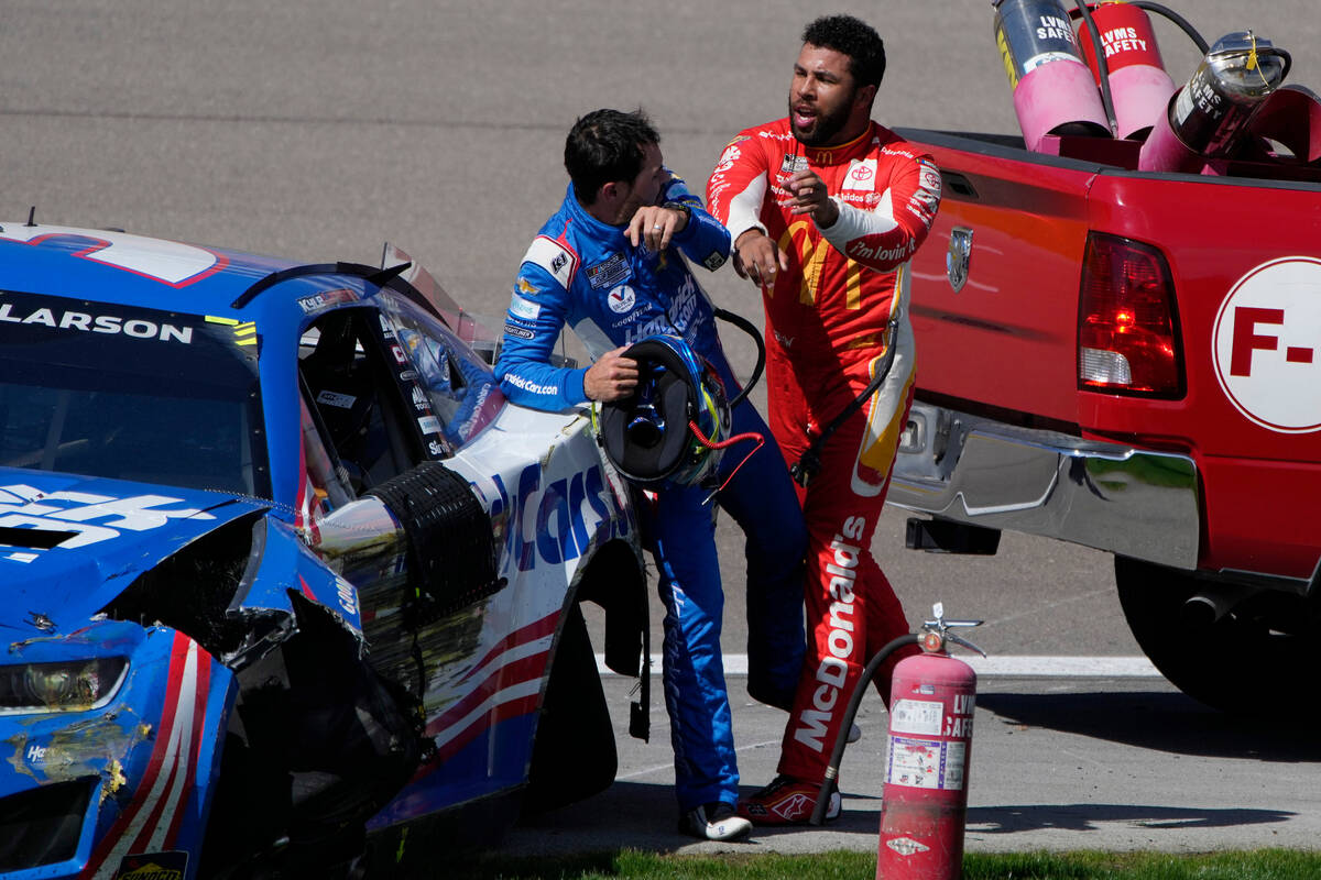 Bubba Wallace, right, pushes Kyle Larson after the two crashed during a NASCAR Cup Series auto ...
