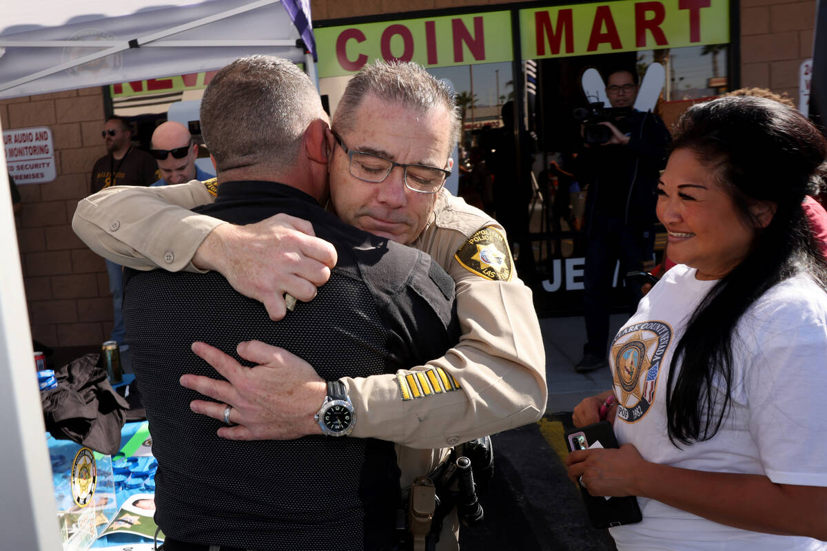 Las Vegas police Assistant Sheriff Andrew Walsh, facing, hugs Las Vegas police officer Sal Masc ...