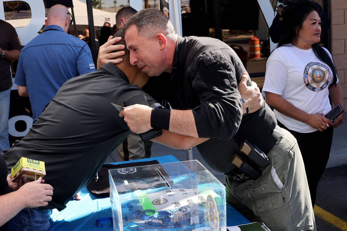 Las Vegas police officer Sal Mascoli, right, hugs Sgt. Charles “JP” Jivapong during an Inju ...