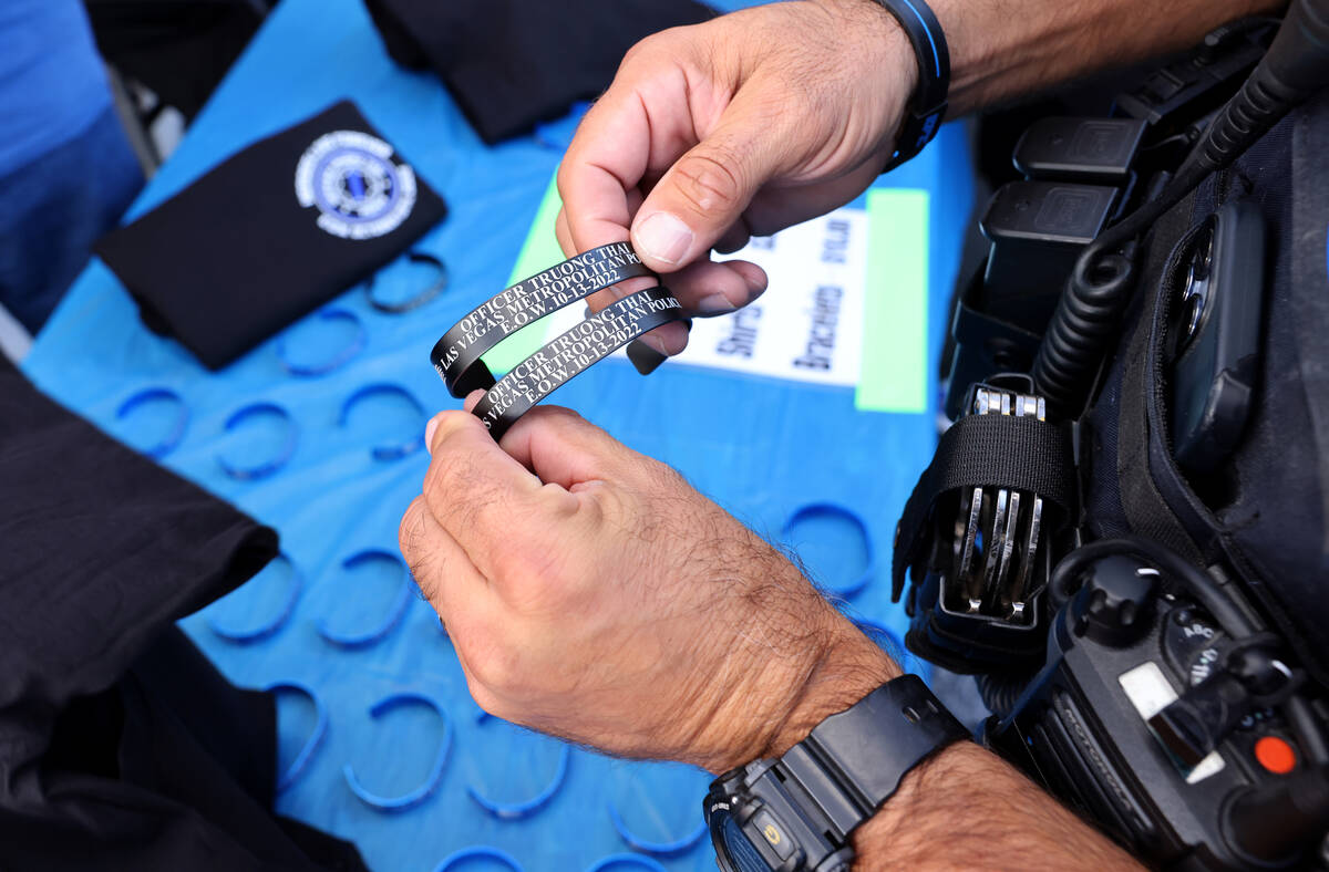 Clark County School District Police Department officer Terry McAninch buys bracelets during an ...
