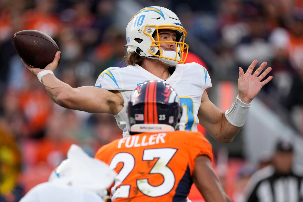 Los Angeles Chargers quarterback Justin Herbert (10) throws as Denver Broncos cornerback Kyle F ...