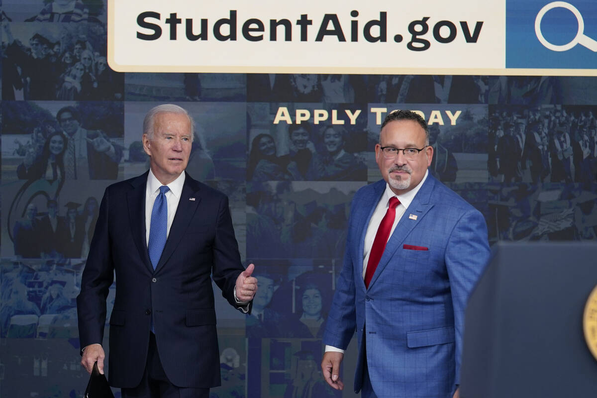 President Joe Biden answers questions with Education Secretary Miguel Cardona as they leave an ...