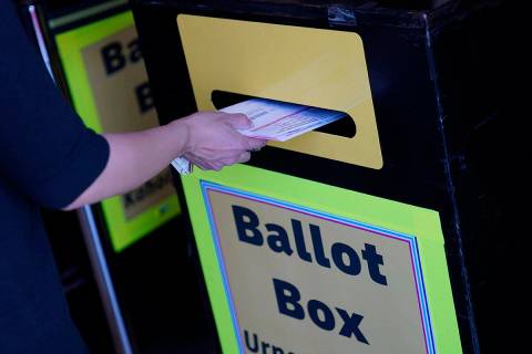 FILE - In this Oct. 29, 2020, file photo, a person places a mail-in ballot in a drop box at the ...