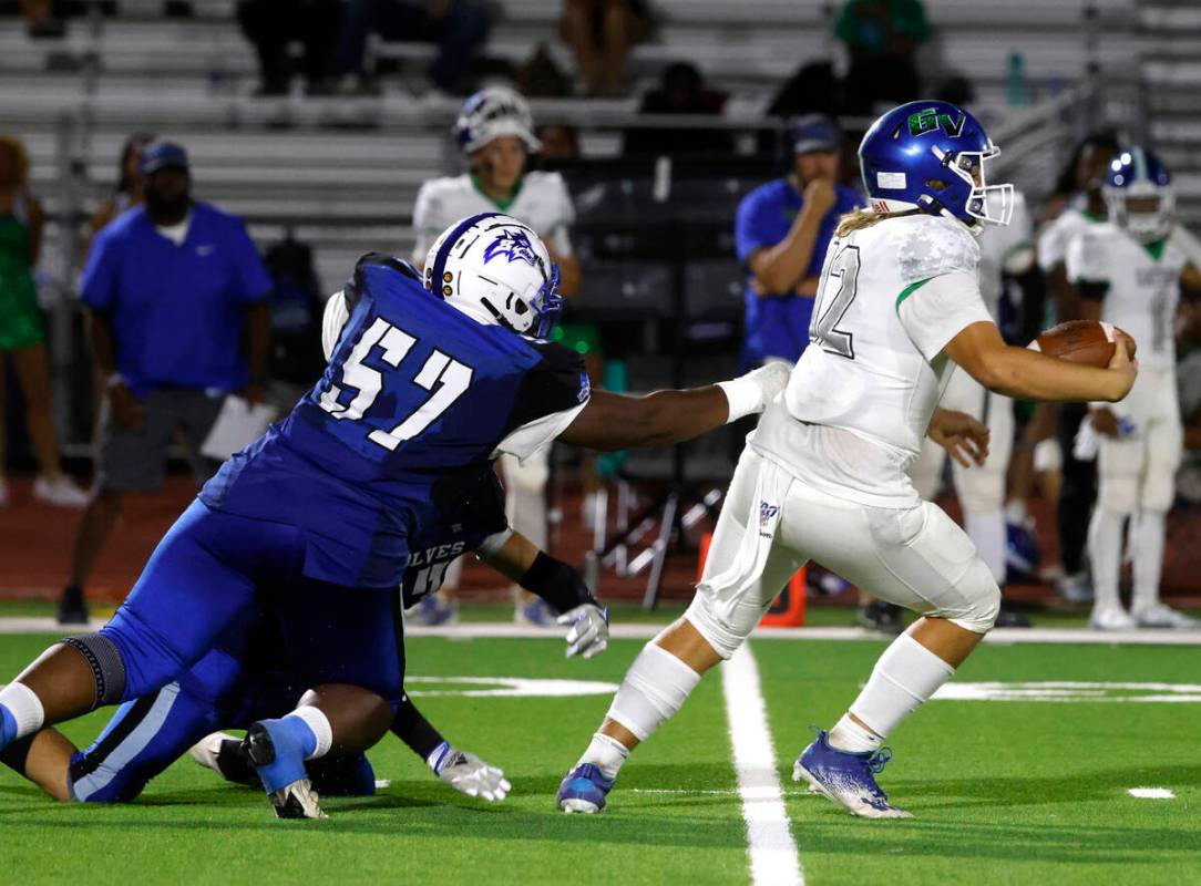 Green Valley High's quarterback Justyn Delzeit (12) i stopped by Basic High's Antoine Taylor jr ...
