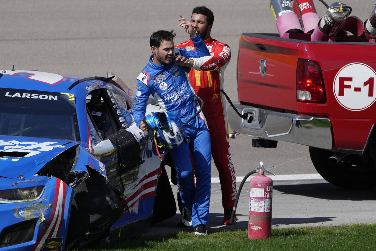 Bubba Wallace, right, pushes Kyle Larson after the two crashed during a NASCAR Cup Series auto ...