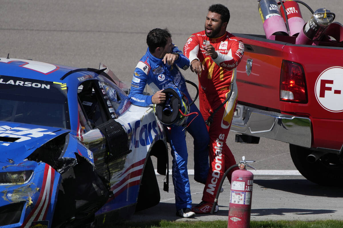 Bubba Wallace, right, pushes Kyle Larson after the two crashed during a NASCAR Cup Series auto ...