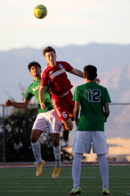 Rancho’s Alan Galvan, left, and Coronado’s Anthony Sena (6) jump to head the ball ...
