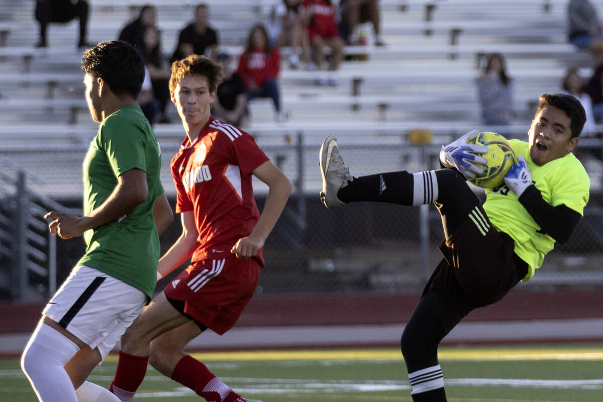 Rancho’s Francisco Beltran, right, falls while saving an attempted goal during a boys hi ...