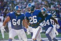 New York Giants' Saquon Barkley (26) celebrates with teammate Marcus Johnson (84) and Mark Glow ...