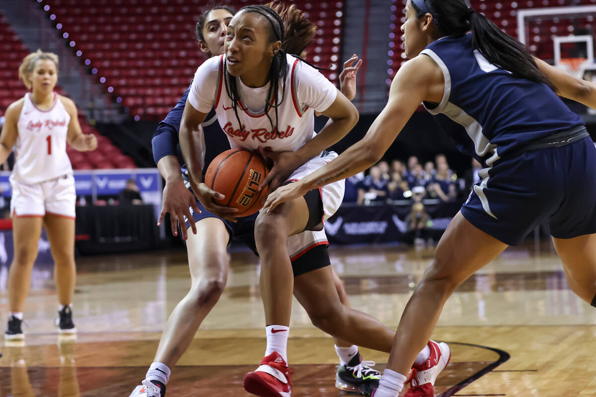 UNLV Lady Rebels guard Justice Ethridge (11) drives to the basket between Utah State Aggies gua ...
